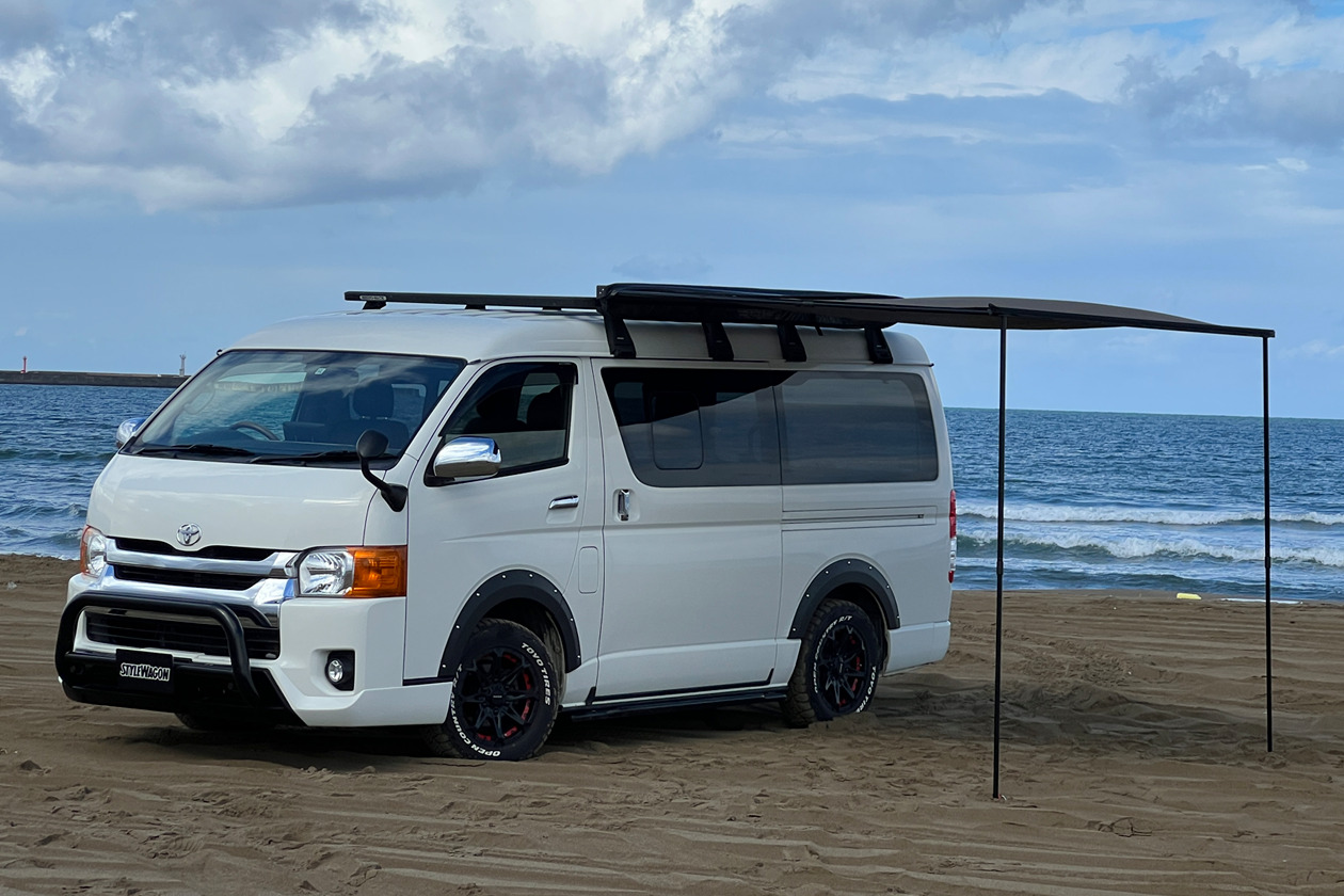 砂浜でオーニングを広げるHIACE