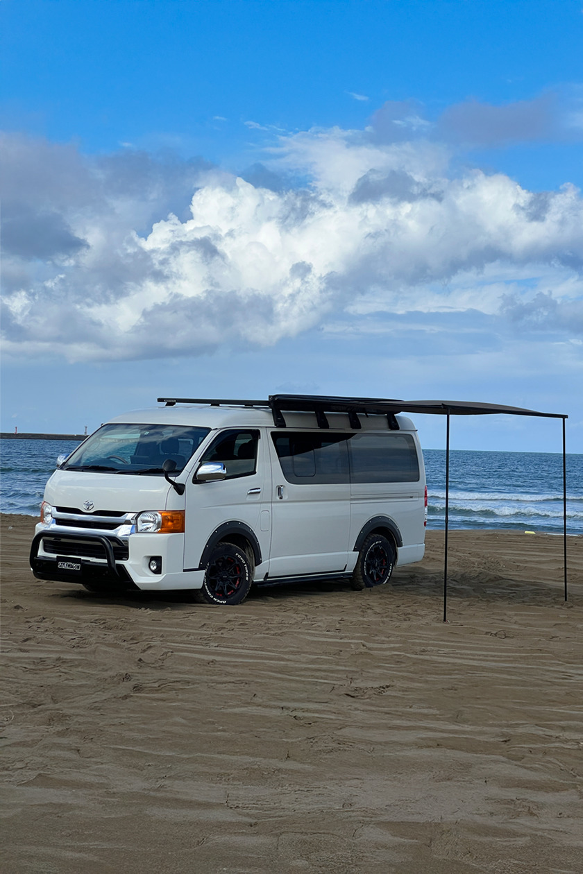 砂浜でオーニングを広げるHIACE